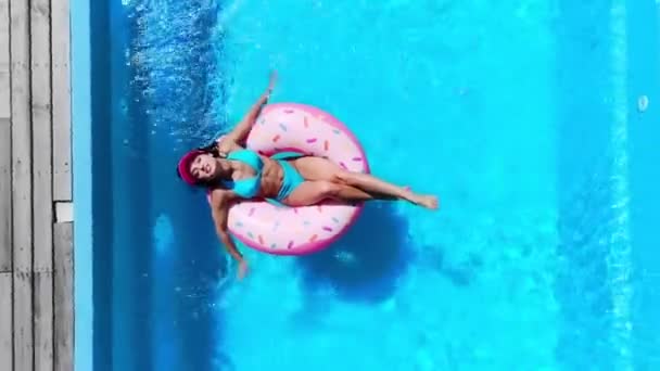 女孩在游泳池里的甜甜圈上放松的头像 — 图库视频影像