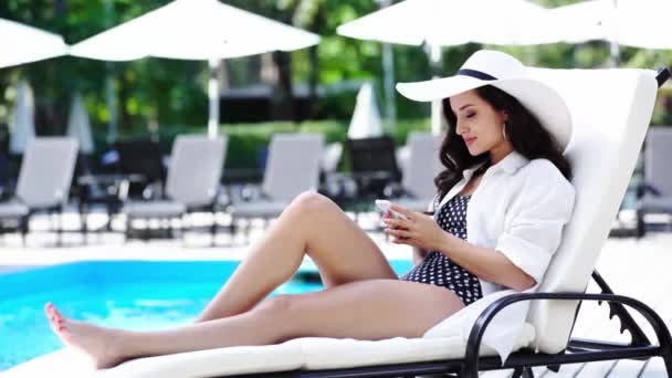 Sourire Belle Fille Utilisant Smartphone Sur Chaise Longue Près Piscine — Video