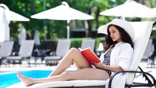 Schönes Mädchen Liest Buch Auf Sonnenliege Der Nähe Von Schwimmbad — Stockvideo