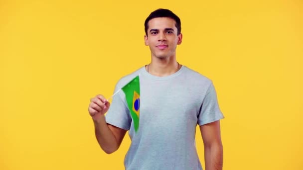 Homem Sorridente Com Pequena Bandeira Brasil Acenando Mão Isolada Amarelo — Vídeo de Stock