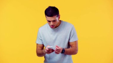 Heyecanlı adam akıllı telefona bakıyor ve sarı renkte izole edilmiş kazanan hareketi gösteriyor.