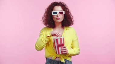 Pembe üzerinde izlenmiş bir film izlerken patlamış mısır yiyen gülümseyen kız.