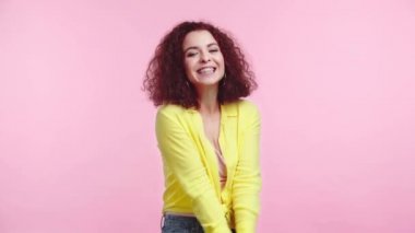 Mutlu, çapkın kız pembe kameraya bakarken gülümsüyor.