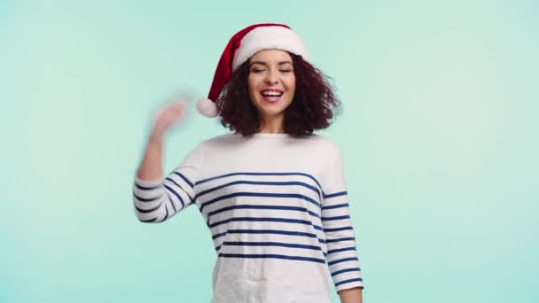 Vrolijk Meisje Santa Hoed Zwaaien Hand Dansen Geïsoleerd Turquoise — Stockvideo