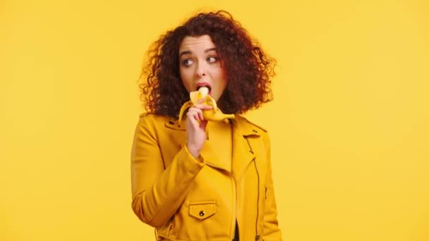 Glad Lockigt Flicka Äter Mogen Banan Isolerad Gul — Stockvideo