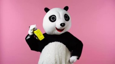 Panda kostümlü insan pembe üzerine izole edilmiş teyple dans ediyor.