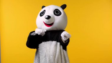 Panda kostümlü kişi sarı alanda izole edilmiş bir tehditle karşı karşıya.