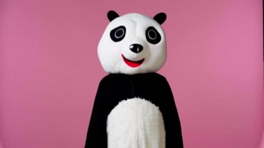 Panda kostümlü bir insan, baş parmağını pembeleşmiş olarak gösteriyor. 