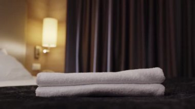 Temizlik görevlisinin otel odasındaki yatağın üstüne temiz havlu koyması.