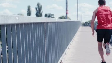 Köprüde koşan genç sporcunun arka görüntüsü