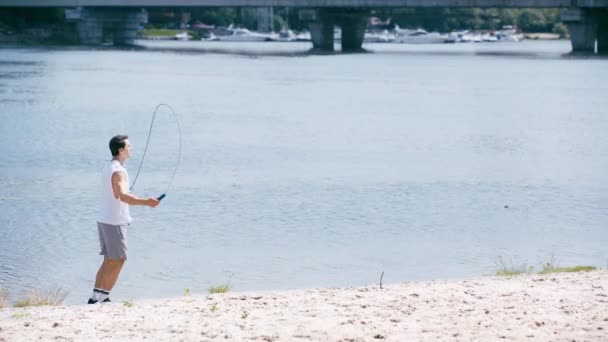 Sidovy Ung Idrottsman Hoppa Med Hopprep Flodstranden — Stockvideo