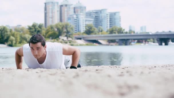 砂の海岸でプッシュしている若いスポーツマンの表面レベルのビュー — ストック動画