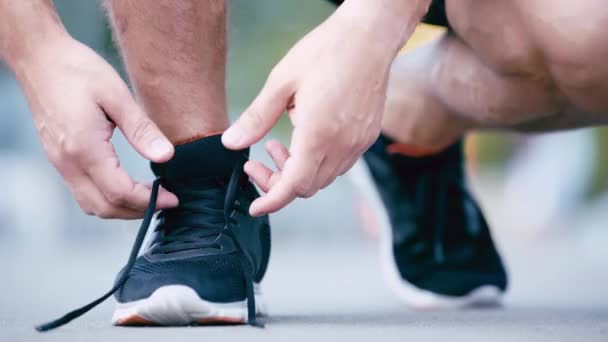 スニーカーに靴ひもを結ぶスポーツマンのクロップドビュー — ストック動画