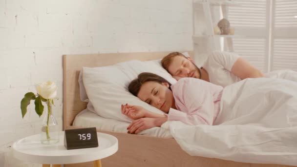 夫妻二人在接近钟时睡在床上 在床头柜的花瓶里站了起来 — 图库视频影像