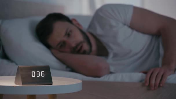 Yatağın Yanındaki Masada Uykusuzluk Çeken Bir Adamın Seçici Odak Noktası — Stok video