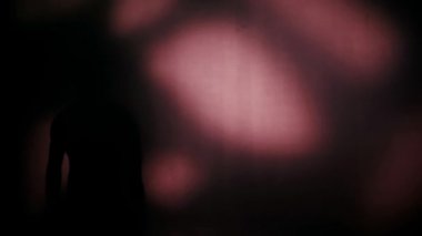 Sporcunun silueti koyu arkaplanda topla çalışıyor