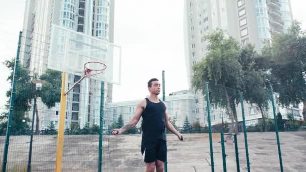 Nízký Úhel Pohledu Sportovce Skákání Skákacím Lanem Blízkosti Basketbalového Ringu — Stock video