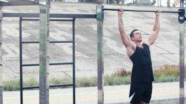 Sokaktaki yatay çubukta sporcu eğitimi