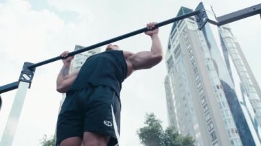 Sokaktaki yatay çubukta sporcu eğitiminin düşük açılı görüntüsü