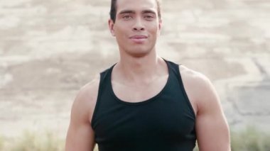 Sporcu zıplıyor, gülümsüyor ve kameraya bakıyor.