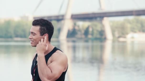 Deportista Escuchando Música Sonriendo Mirando Cámara Cerca Del Río Calle — Vídeo de stock