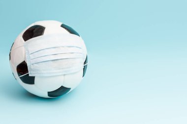 Medikal maskeli futbol topu mavi üzerine fotokopi alanı