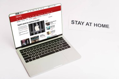 KYIV, UKRAINE - 8 Nisan 2020: BBC haber sitesi olan dizüstü bilgisayar, kağıdın yanında beyaz harflerle evde kalıyor. 