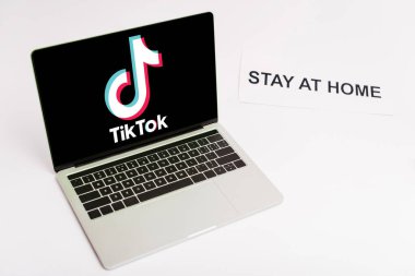 KYIV, UKRAINE - 8 Nisan 2020: ekranda Tik tok web sitesi olan dizüstü bilgisayar beyaz harflerle evde duruyor 