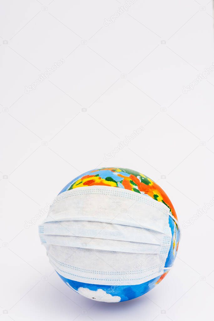 globe in protective medical mask on white with copy space