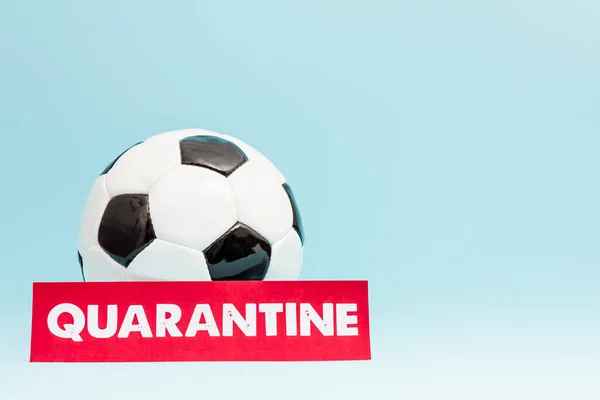 Football near paper with quarantine lettering on blue — Stock Photo