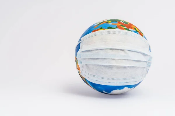 Globe in medical mask on white with copy space — Stock Photo