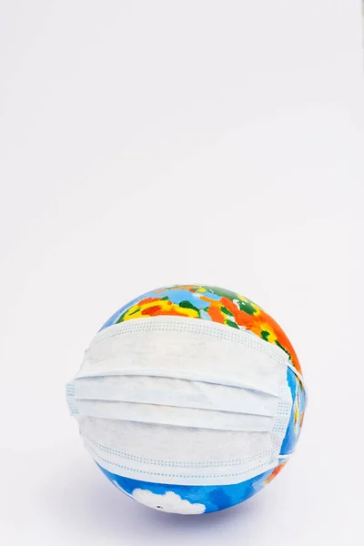 Globo en máscara médica protectora en blanco con espacio de copia - foto de stock