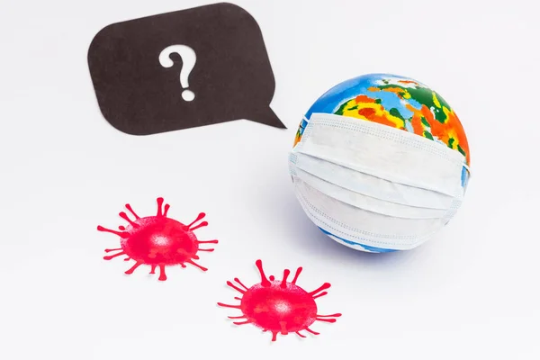 Globe in medical mask near speech bubble with question mark and drawn virus on white — Stock Photo