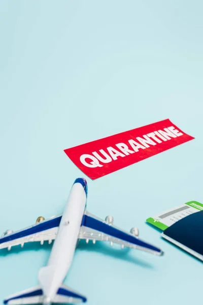 Toy plane near paper with quarantine, passport and boarding pass on blue — Stock Photo