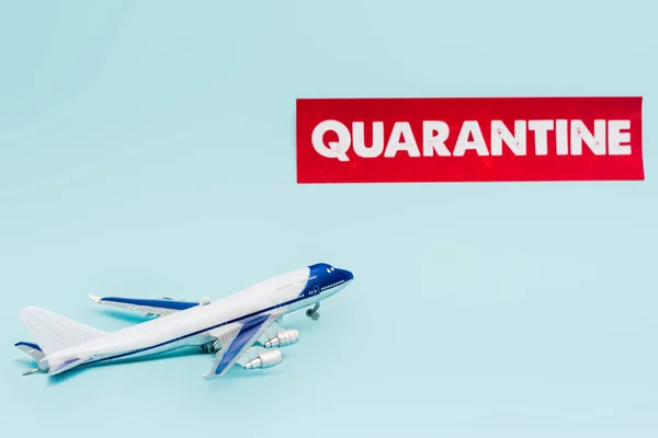 Jouet avion près de papier avec lettrage de quarantaine isolé sur bleu — Photo de stock