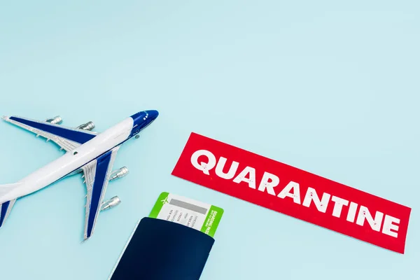 Іграшковий літак біля паперу з карантином, паспортом та авіаквитком ізольовано на синьому — стокове фото