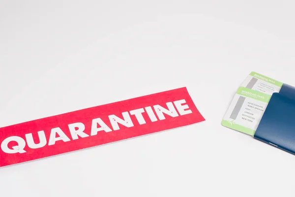 High angle view of card with quarantine lettering and passports with air tickets on white background — Stock Photo