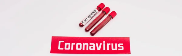 Website header of card with coronavirus lettering near test tubes with blood samples on white — Stock Photo