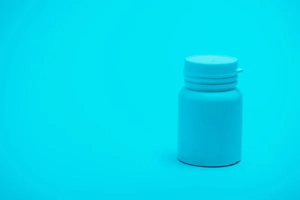 Envase blanco con pastillas sobre fondo azul - foto de stock