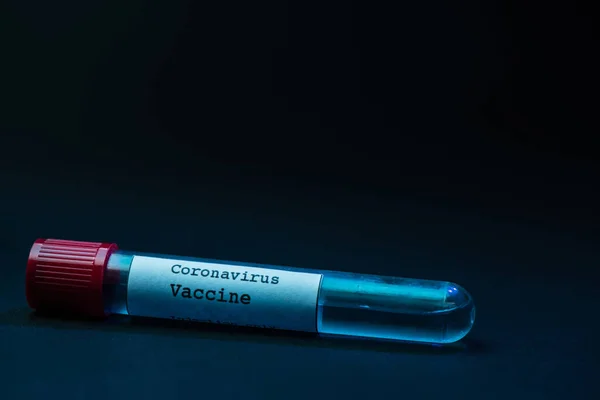 Sample tube of coronavirus vaccine on dark background — Stock Photo