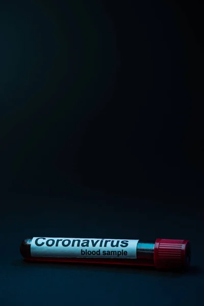 Tubo de ensaio com amostra de sangue de coronavírus sobre fundo escuro — Fotografia de Stock