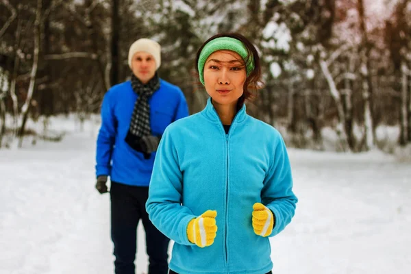 年轻夫妇穿着暖和的羊毛和手套在阳光下慢跑 穿过冬天的雪在农村 — 图库照片