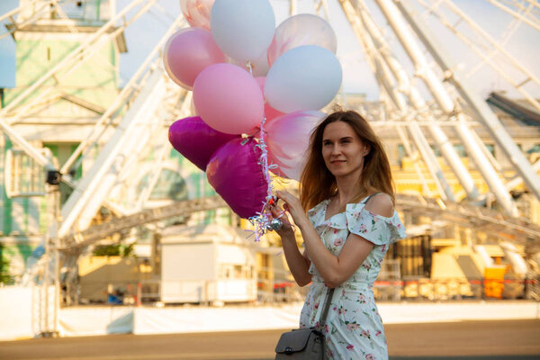 city urban woman enjoying view of downtown . Fashionable girls with balloons, summer travel in Europe.