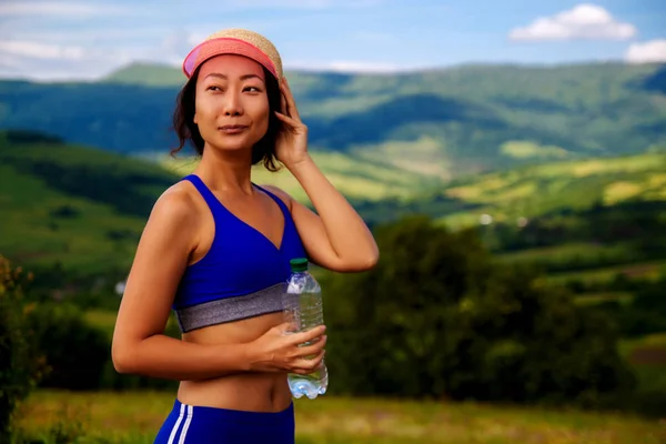 健康美丽的亚洲女人在炎炎夏日的小山上锻炼之后 一边喝水 一边出汗 女运动员运动后 — 图库照片