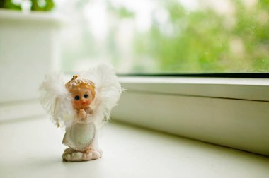 Beyaz, küçük, güzel bir melek. Beyaz bir arka planda seramik bir figür..