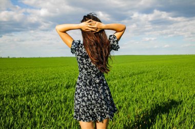 Yeşil sahada duran mutlu genç bayanın sırtında Temiz havanın keyfini çıkarın.