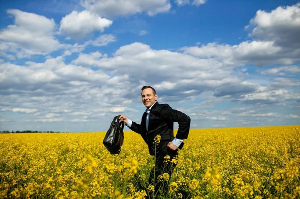 Successful Businessman With A Briefcase Gallops Dancing In The Field.