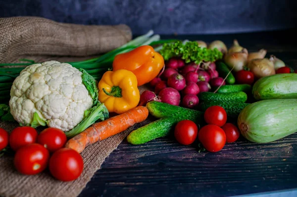 Masada taze organik sebzeler var. Sağlıklı yiyecekler. Tahta bir arka planda taze sebzeler.