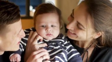 Mutlu bir anne kucağında bebeğini sakinleştiriyor.