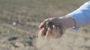 İnsan elleri kara bereketli topraktan bir örnek alır.